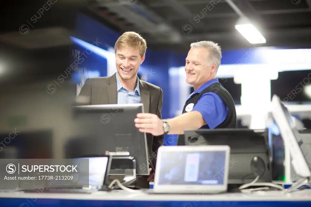 Young man looking at computers in showroom