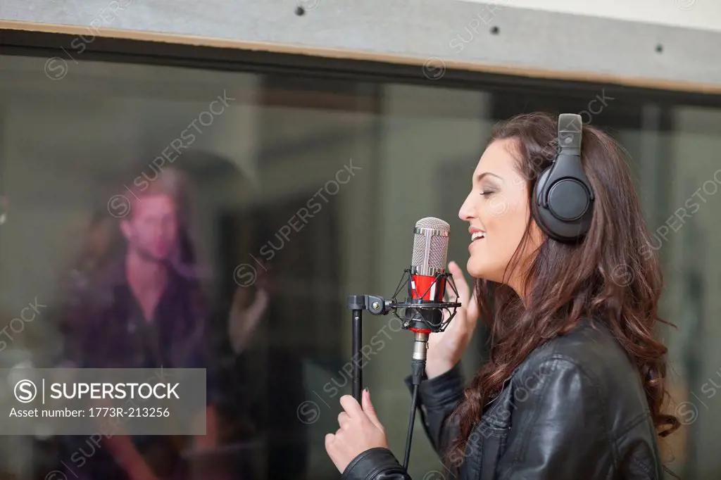 Young female singer in recording studio
