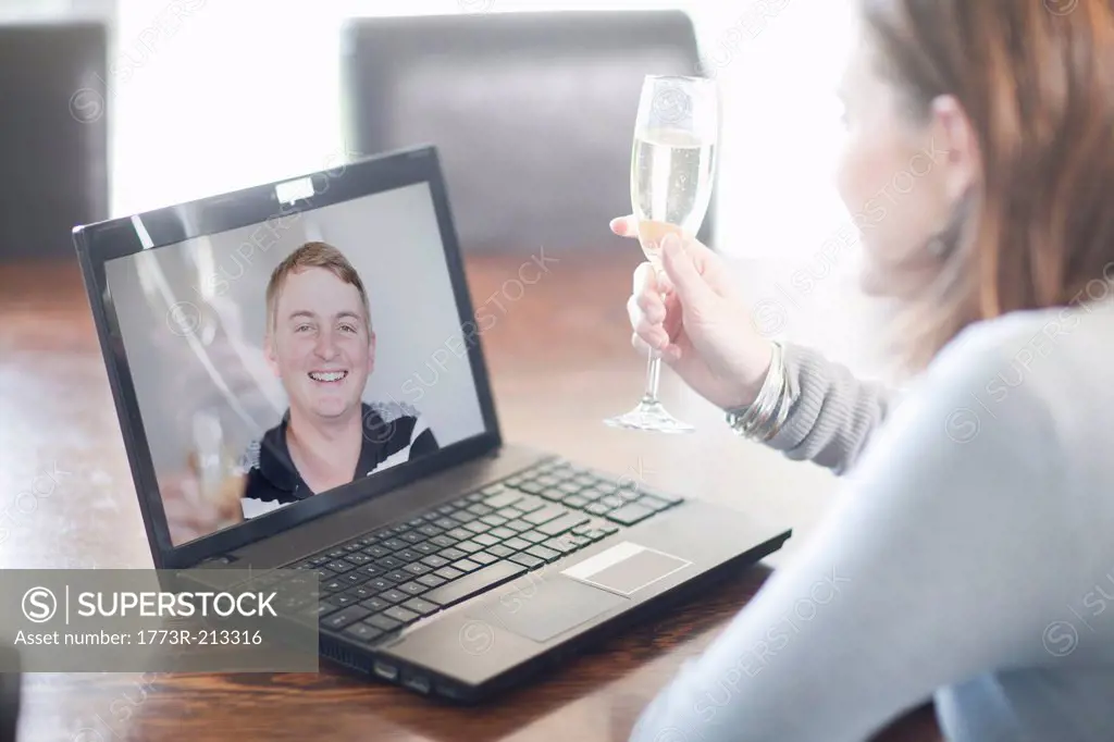 Woman toasting husband using video call