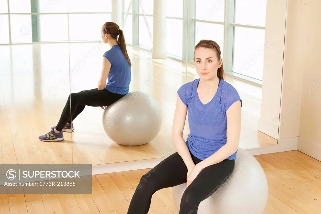 Woman on exercise ball in gymnasium