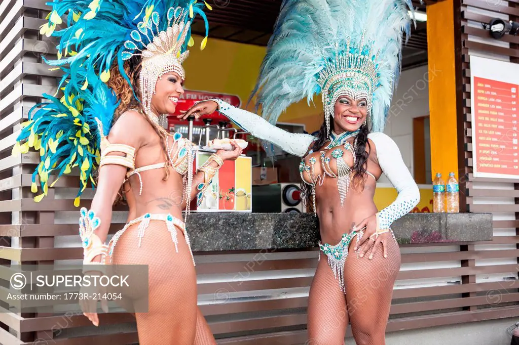 Samba dancers in costume by food stall, Rio De Janeiro, Brazil
