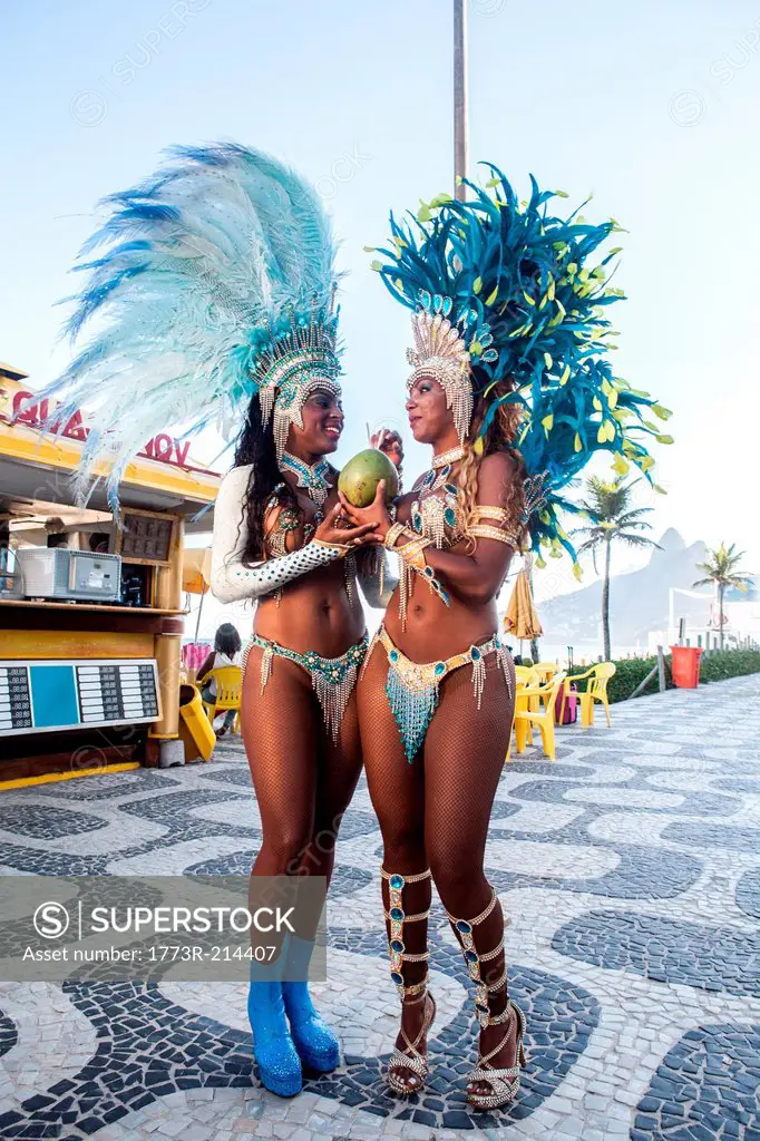 Samba dancers drinking coconut drink, Ipanema Beach, Rio De Janeiro, Brazil