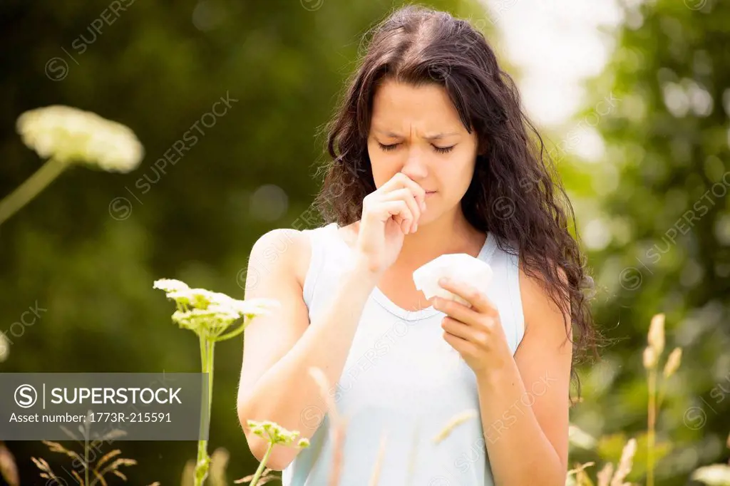 Girl with tissue rubbing nose