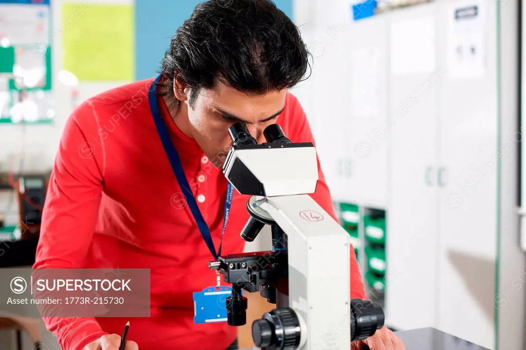 Chemistry student using microscope in laboratory