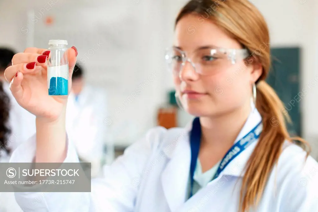 Chemistry student holding blue chemical
