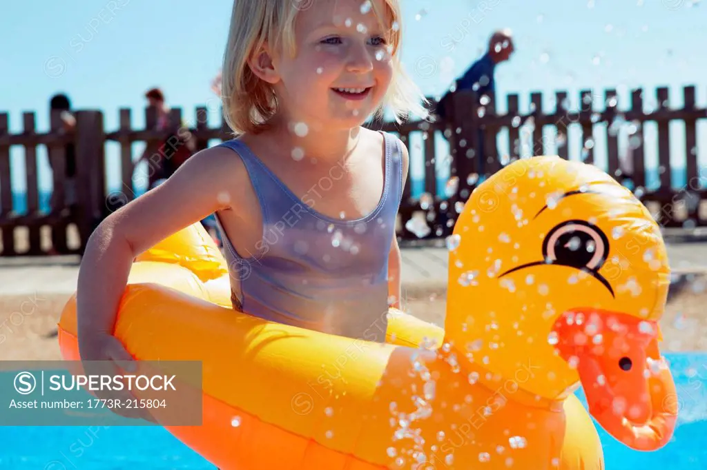 Child with duck-shaped float in pool
