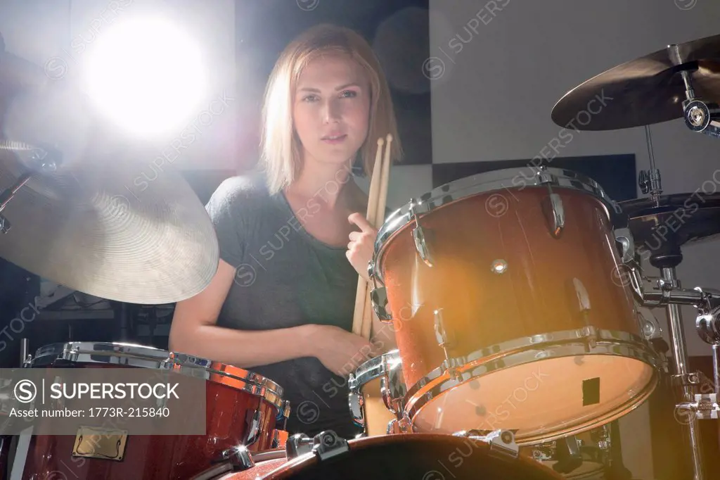 Female drummer sitting behind drums