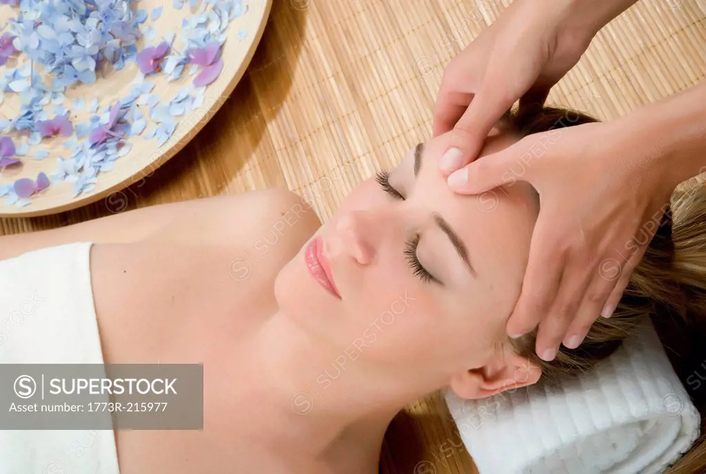 Woman at spa having forehead massaged
