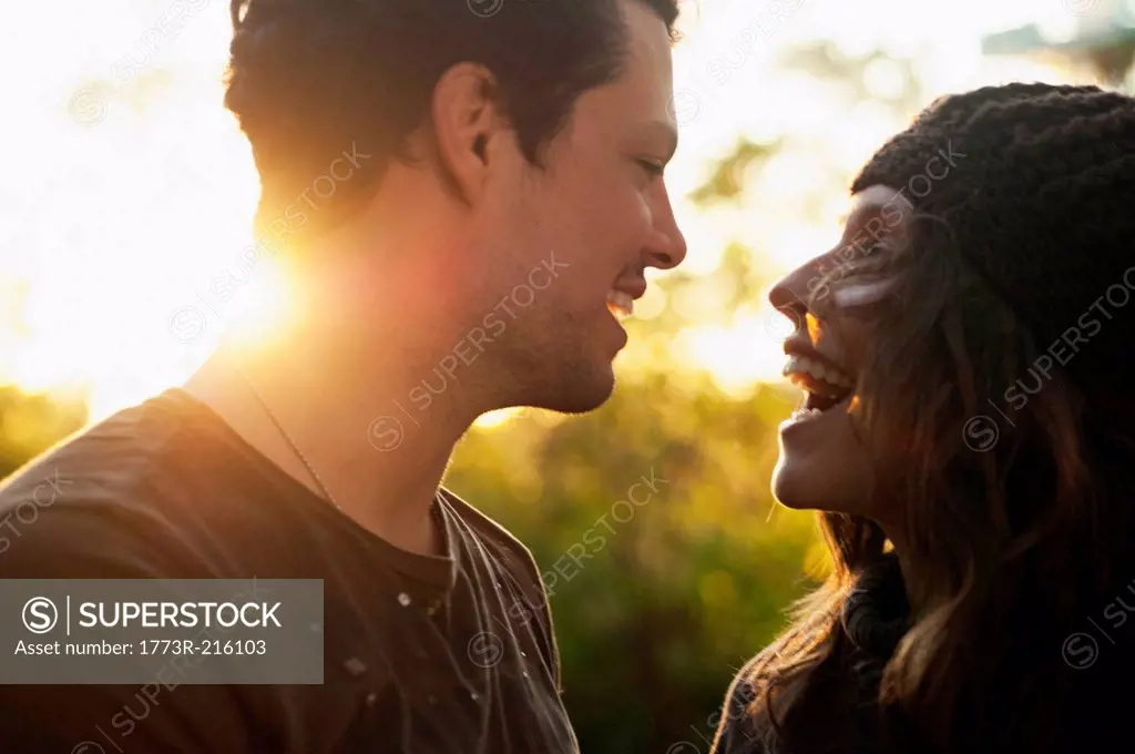 Portrait of couple in autumn sunlight laughing