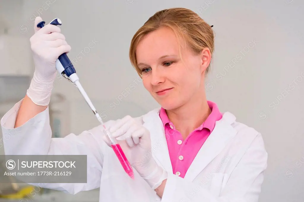 Female scientist pipetting liquid for reaction mixture