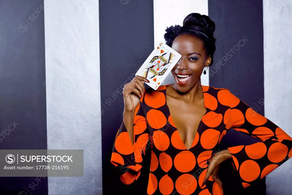 Young woman posing with playing card