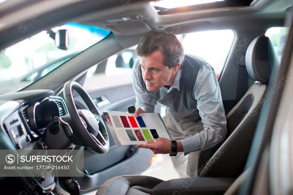 Mid adult man with color swatch in car showroom