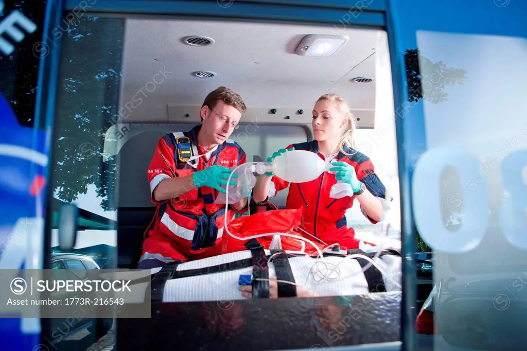 Paramedics ventilating patient in ambulance
