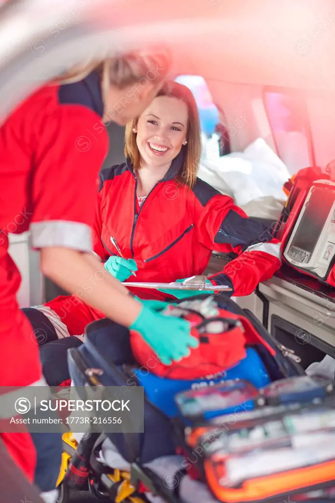 Two female paramedics in ambulance checking equipment