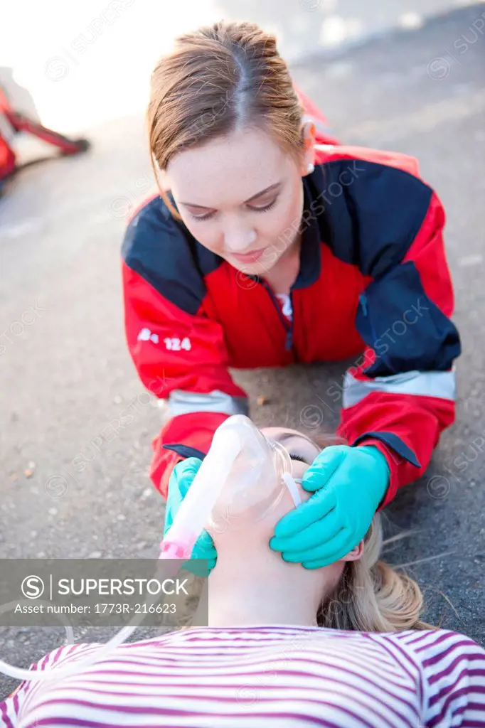 Female paramedic tending patient on road