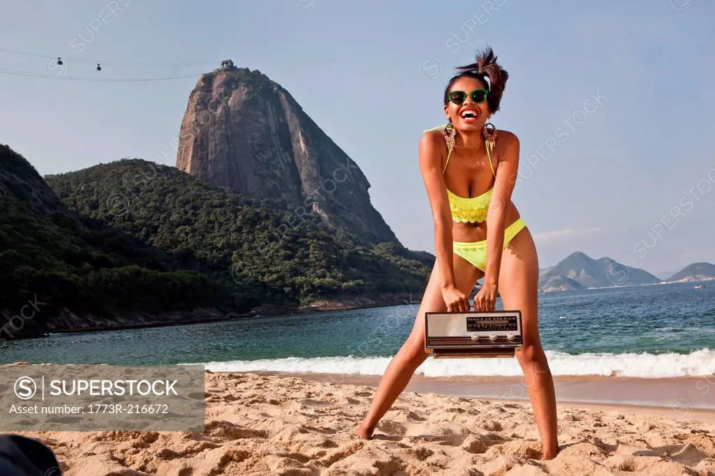 Woman on beach with vintage radio, Rio de Janeiro, Brazil