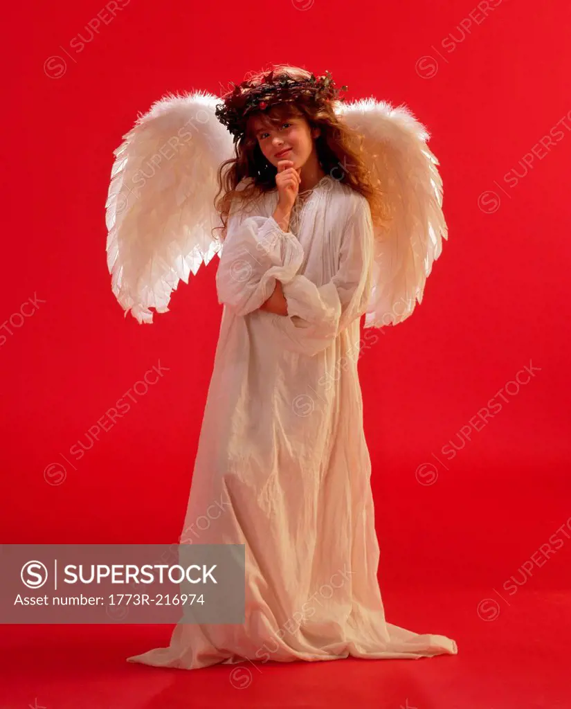 Girl dressed as angel against red background