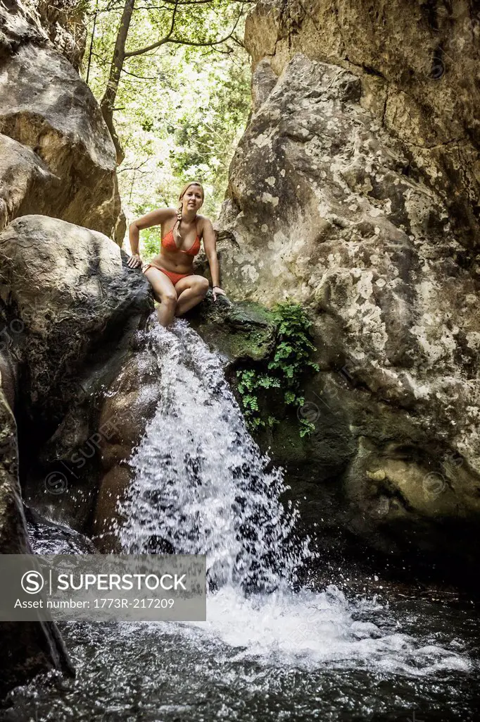 Woman wearing bikini at top of Potami waterfalls in Samos, Greece
