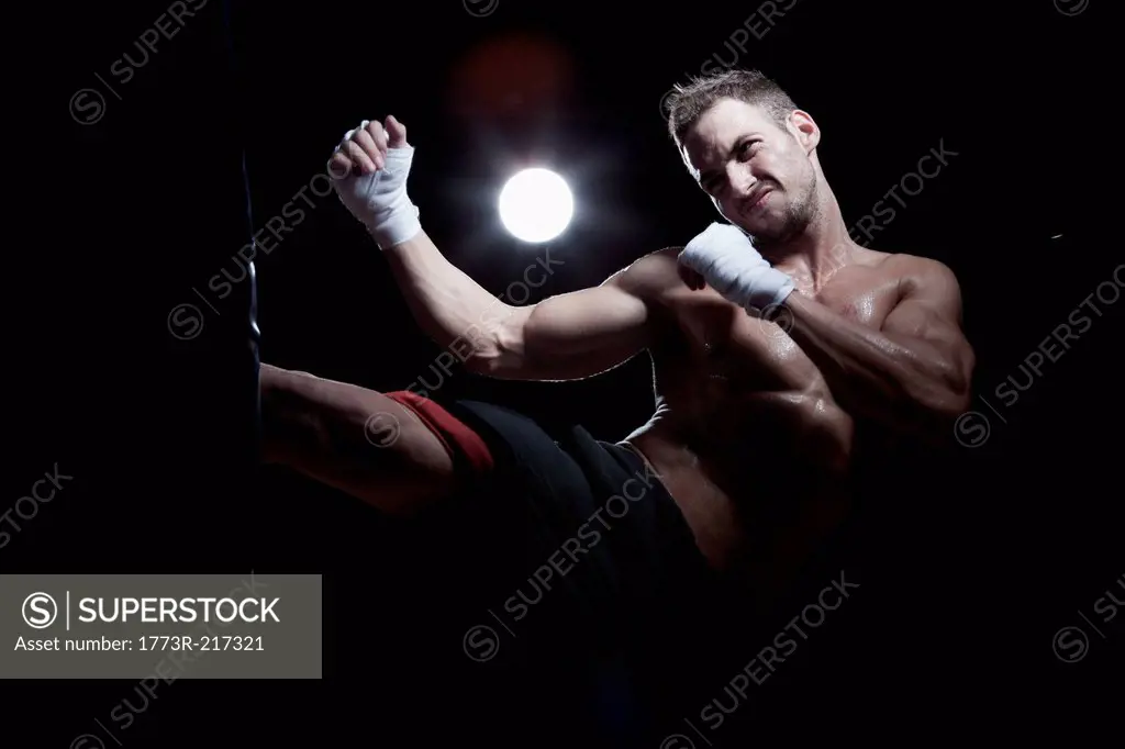 Boxer kicking punch bag