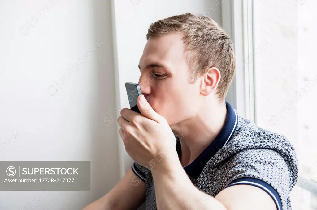 Man kissing mobile phone