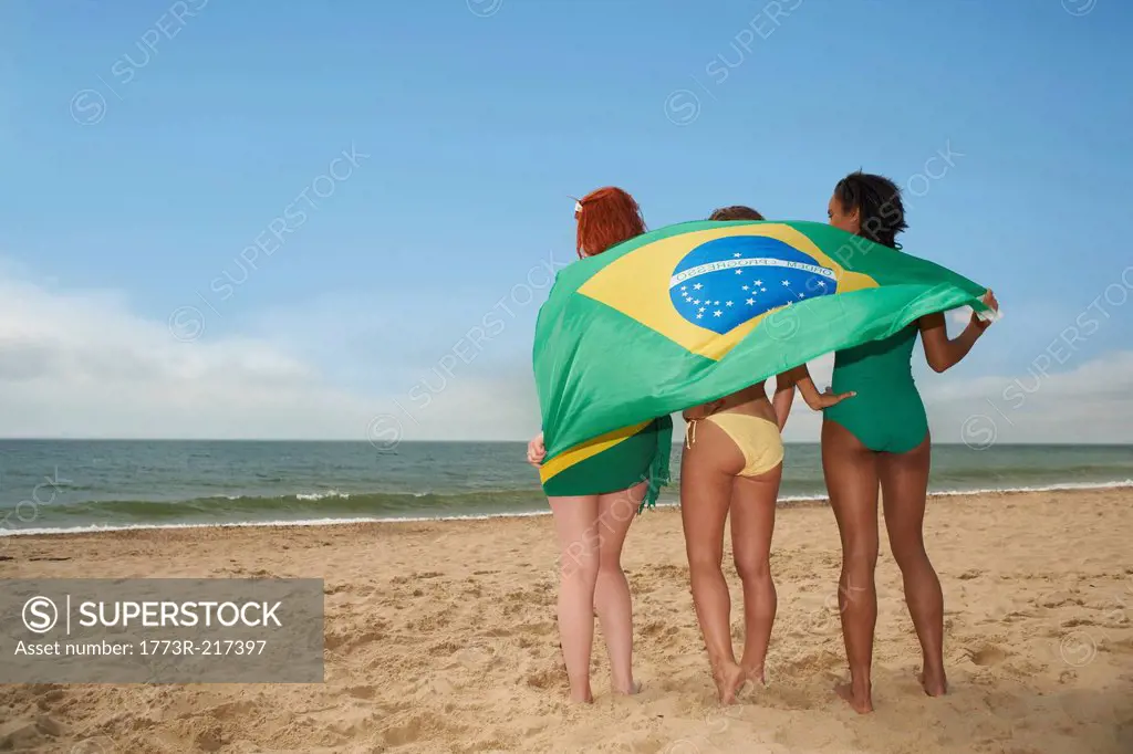 Rear view of women with brazilian flag on beach