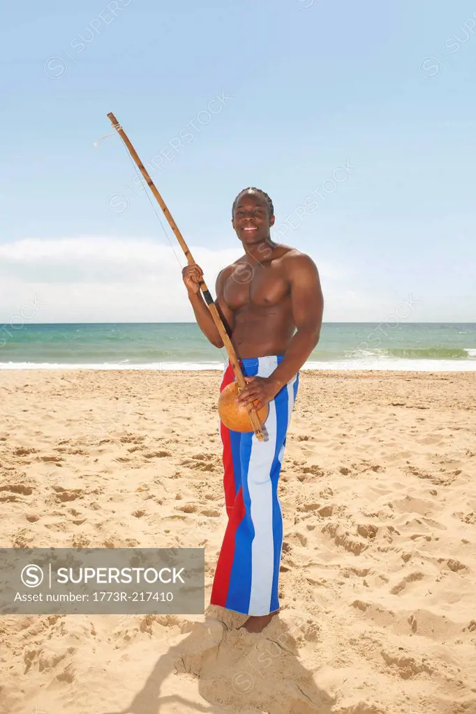 Man with berimbau on beach