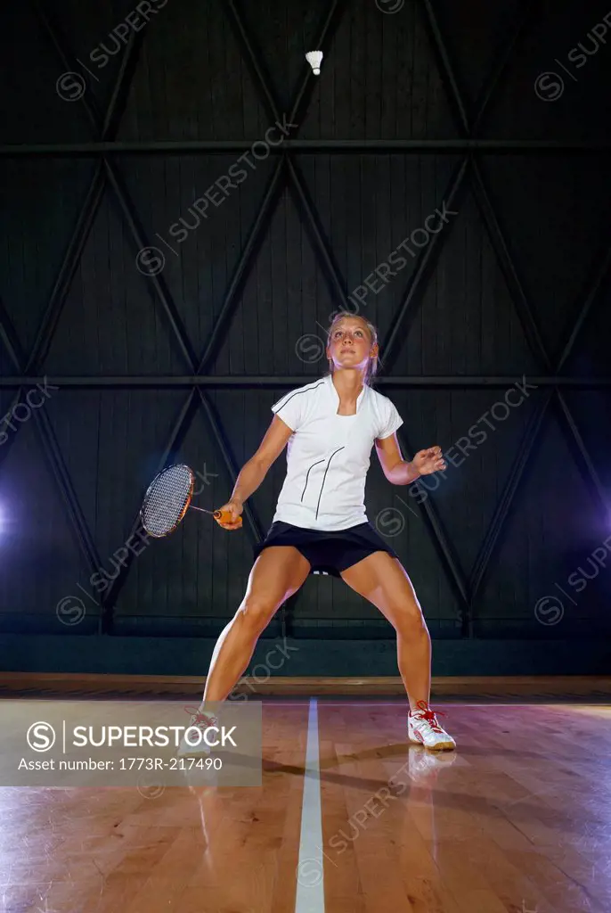 Young woman playing badminton on court