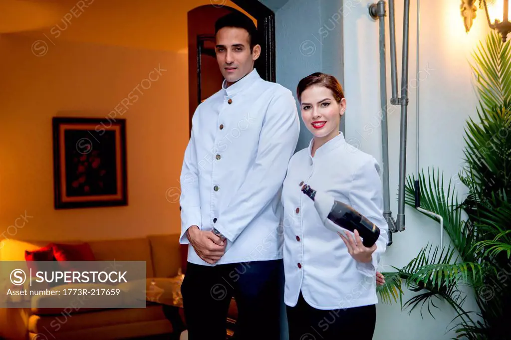 Hotel staff at entrance with bottle of champagne