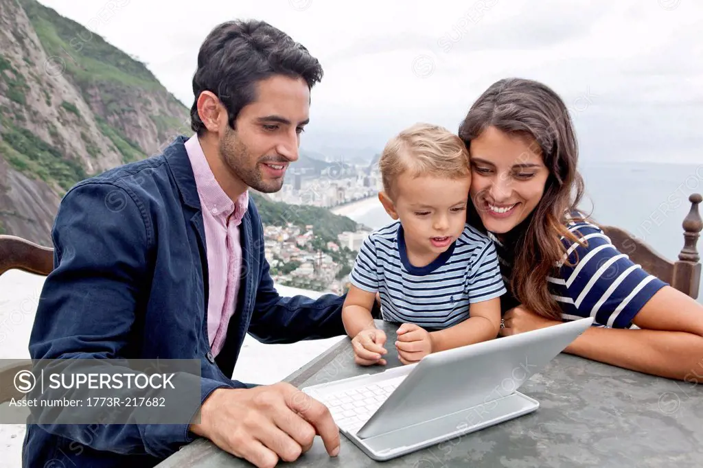 Young family with laptop, Casa Alto Vidigal, Rio De Janeiro, Brazil
