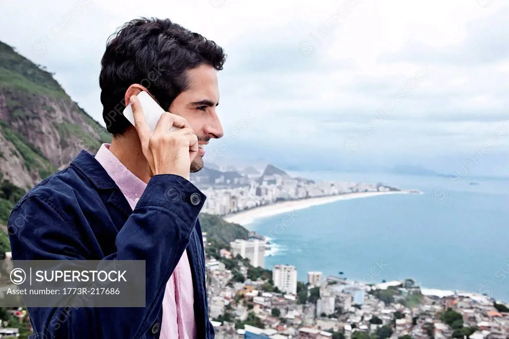 Young man using mobile phone, Casa Alto Vidigal, Rio De Janeiro, Brazil