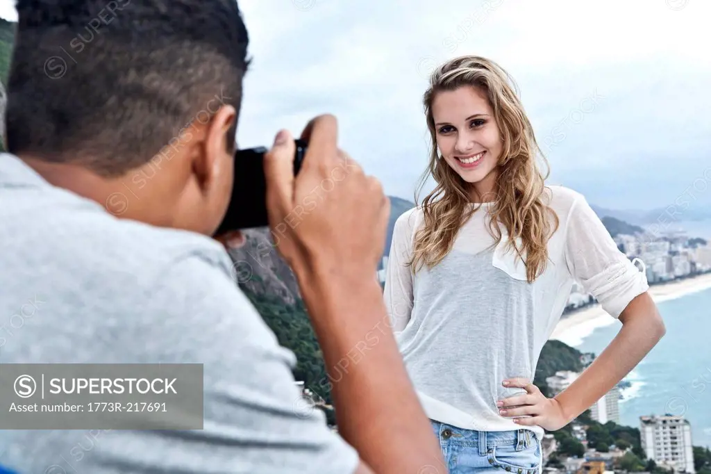 Young man photographing girlfriend, Casa Alto Vidigal, Rio De Janeiro, Brazil