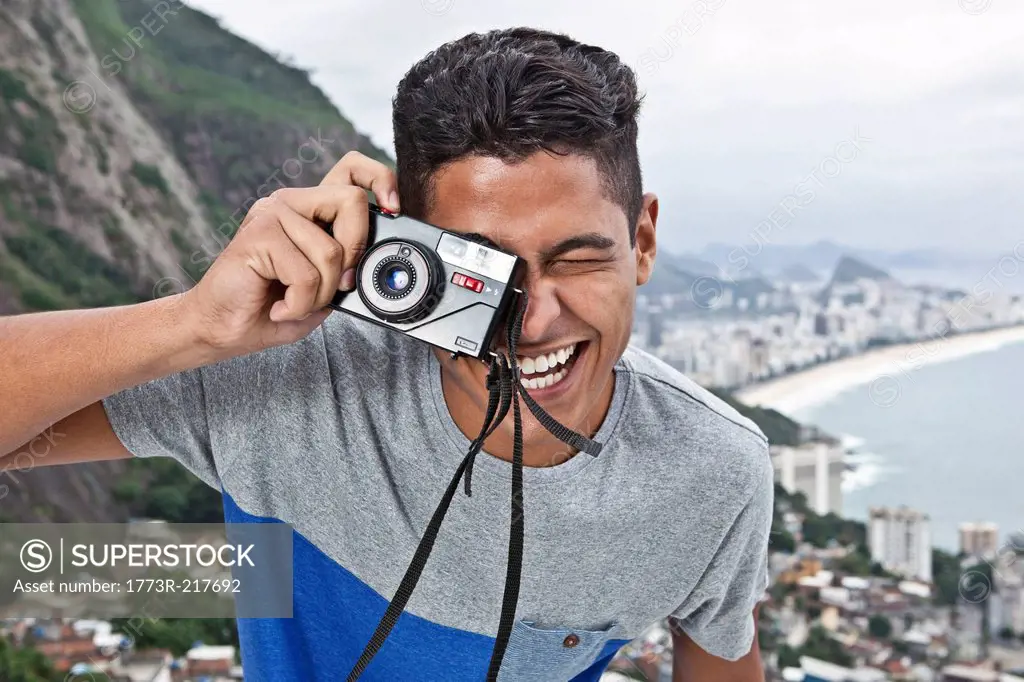 Portrait of young man with camera, Casa Alto Vidigal, Rio De Janeiro, Brazil