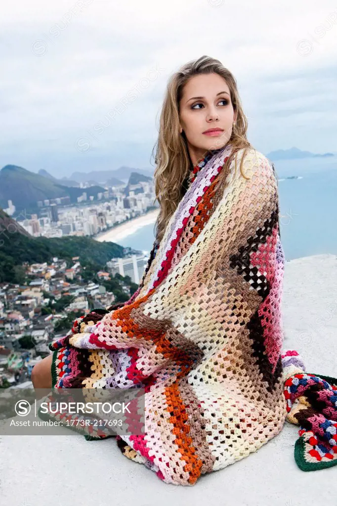 Young woman wrapped in wool blanket, Casa Alto Vidigal, Rio De Janeiro, Brazil