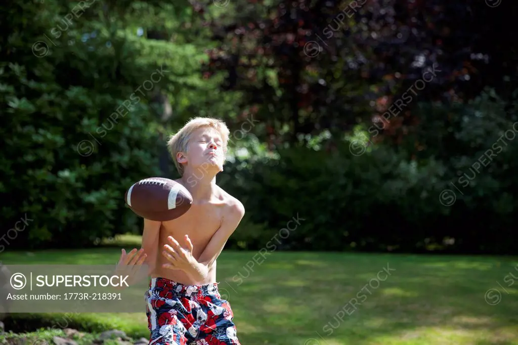Boy in garden catching rugby ball