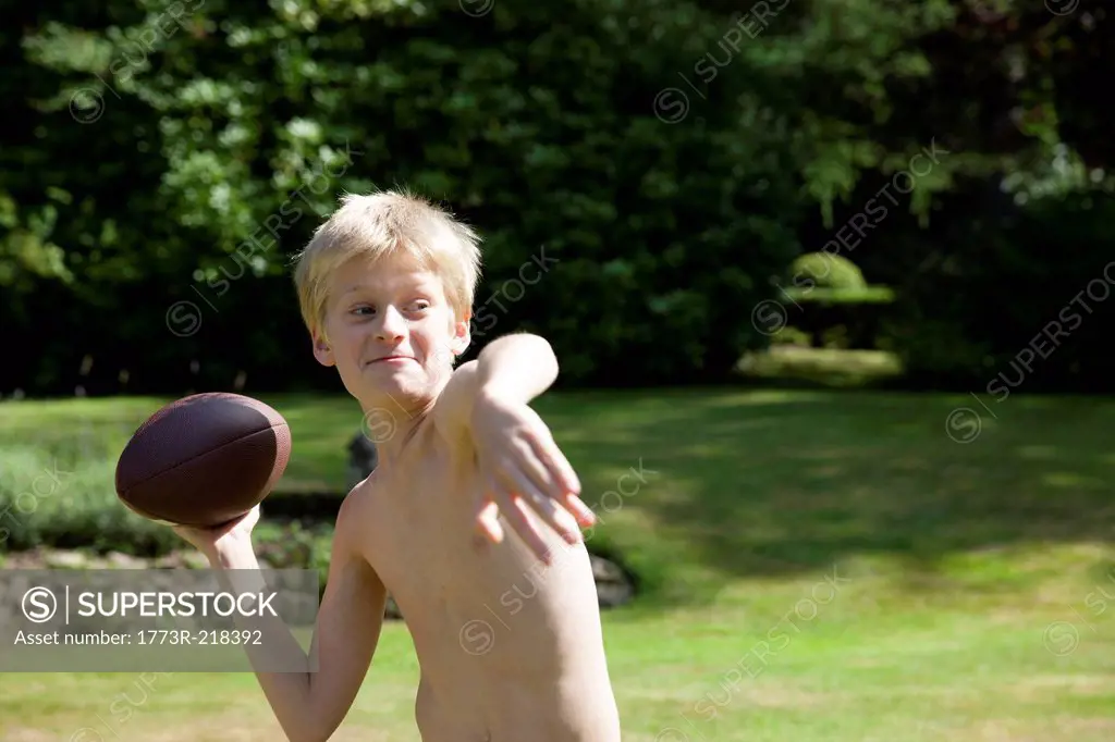 Boy in garden throwing rugby ball