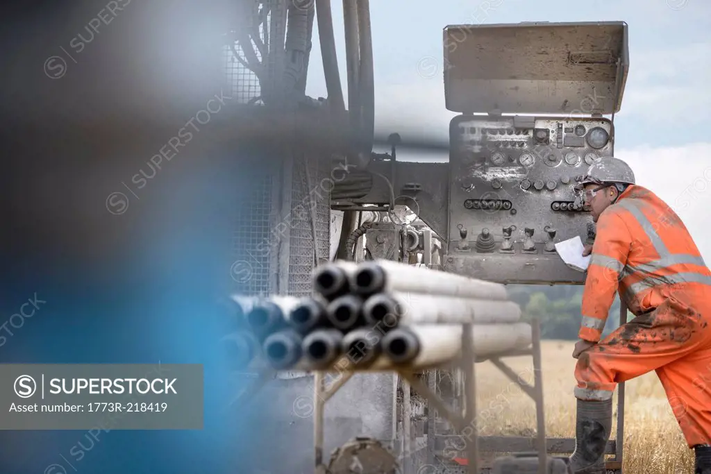 Drilling rig worker inspecting machinery