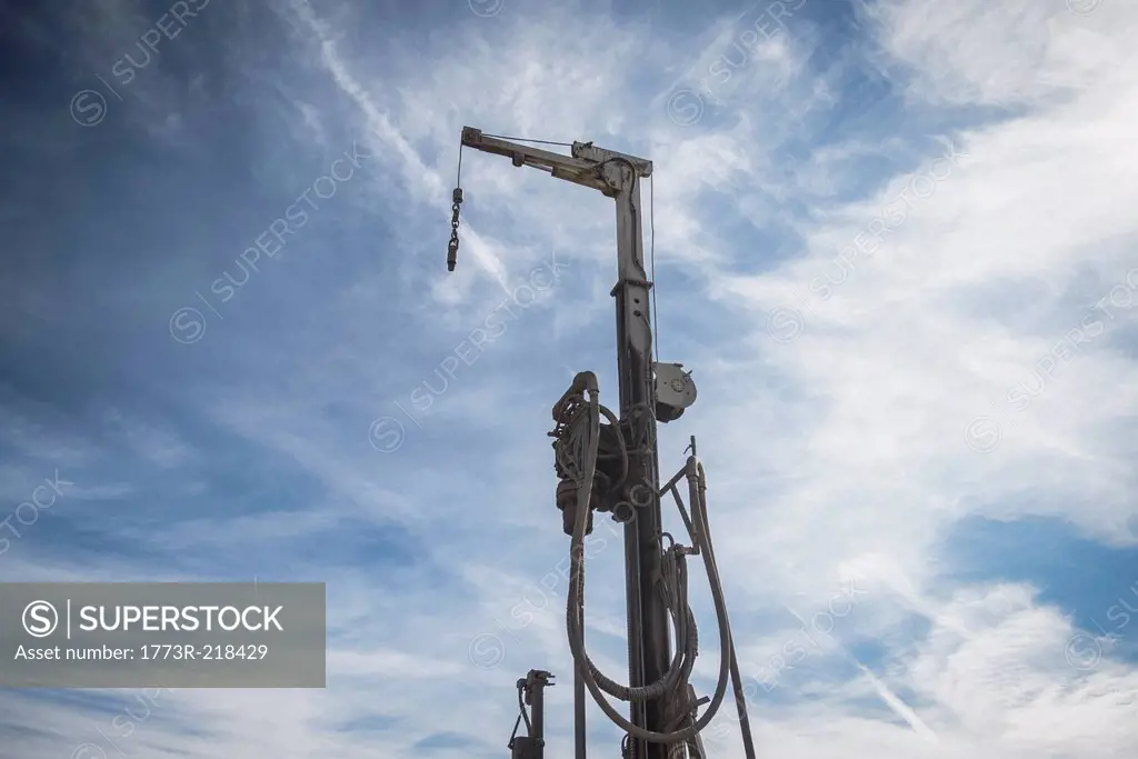 Low angle view of drilling rig against blue sky