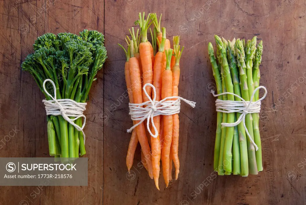 Bunches of carrots, broccoli and asparagus tied with string, still life