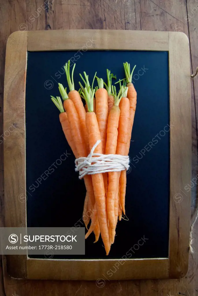 Bunch of carrots on blackboard, still life