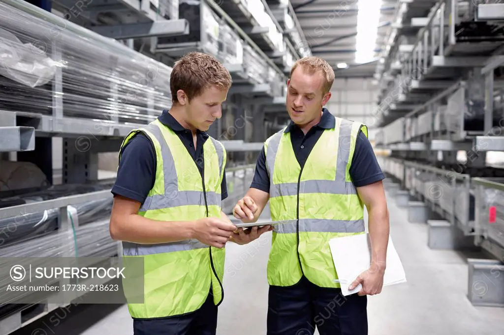 Workers checking orders in engineering warehouse