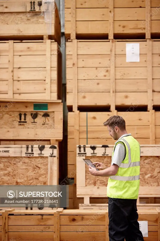 Warehouse worker checking crates in engineering warehouse