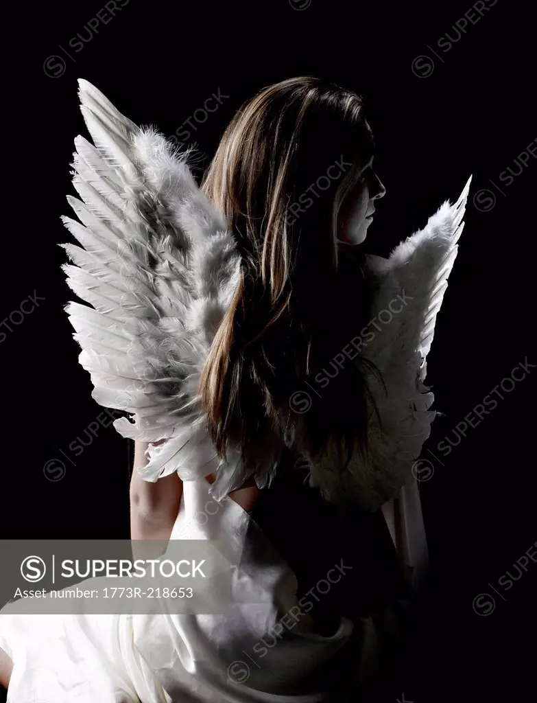 Studio portrait of pensive woman wearing angel wings