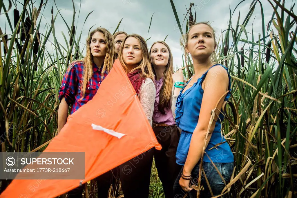 Portrait of five young women in marshes holding kite
