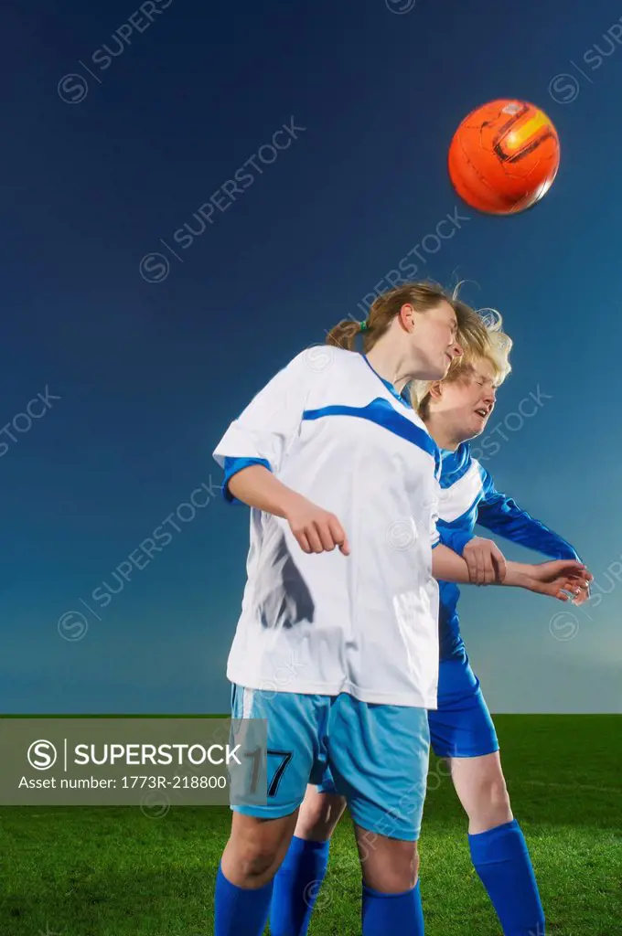 Female footballers heading the ball