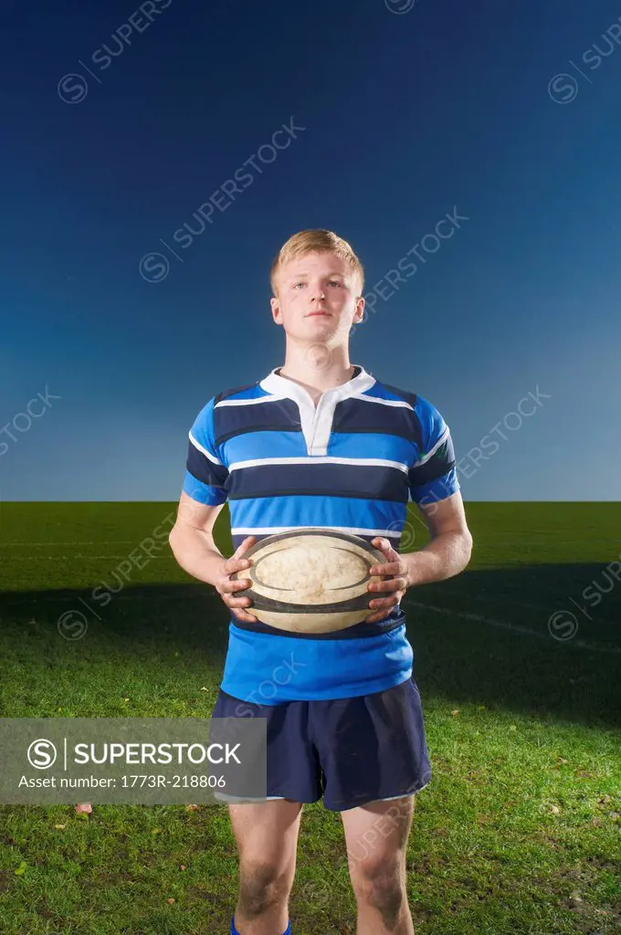 Portrait of young man holding rugby ball