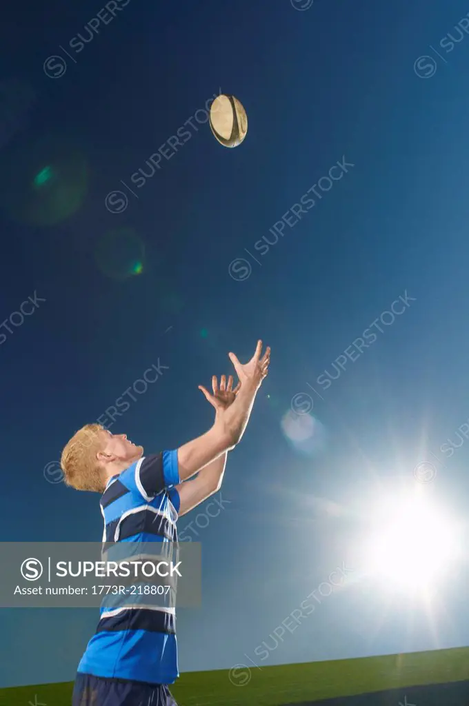 Young man catching rugby ball
