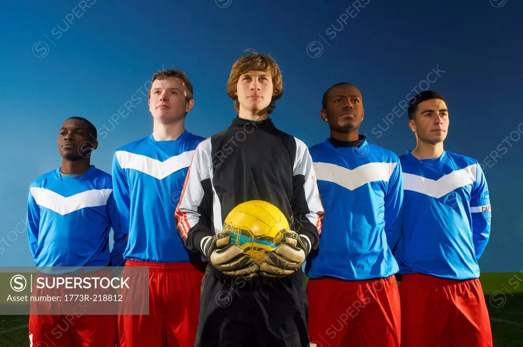 Portrait of football team, goalkeeper holding ball