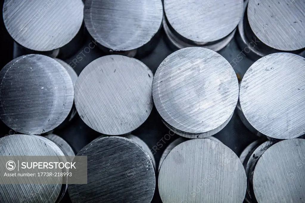 Stacks of raw and unworked steel discs in factory, overhead view