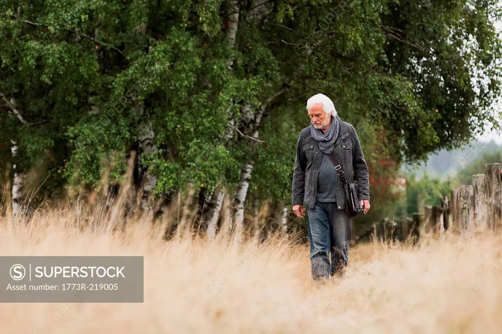 Senior man walking in meadow