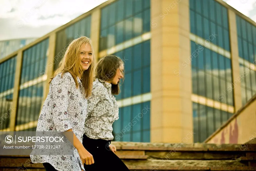 Two young women walking in front of office bulding